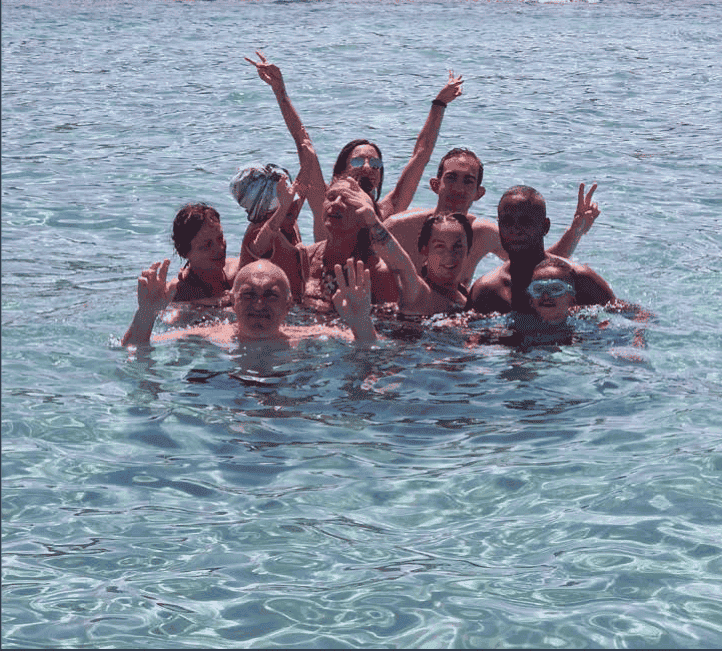 Groupe d'amis savourant la baignade dans les eaux limpides face à une plage déserte corse.